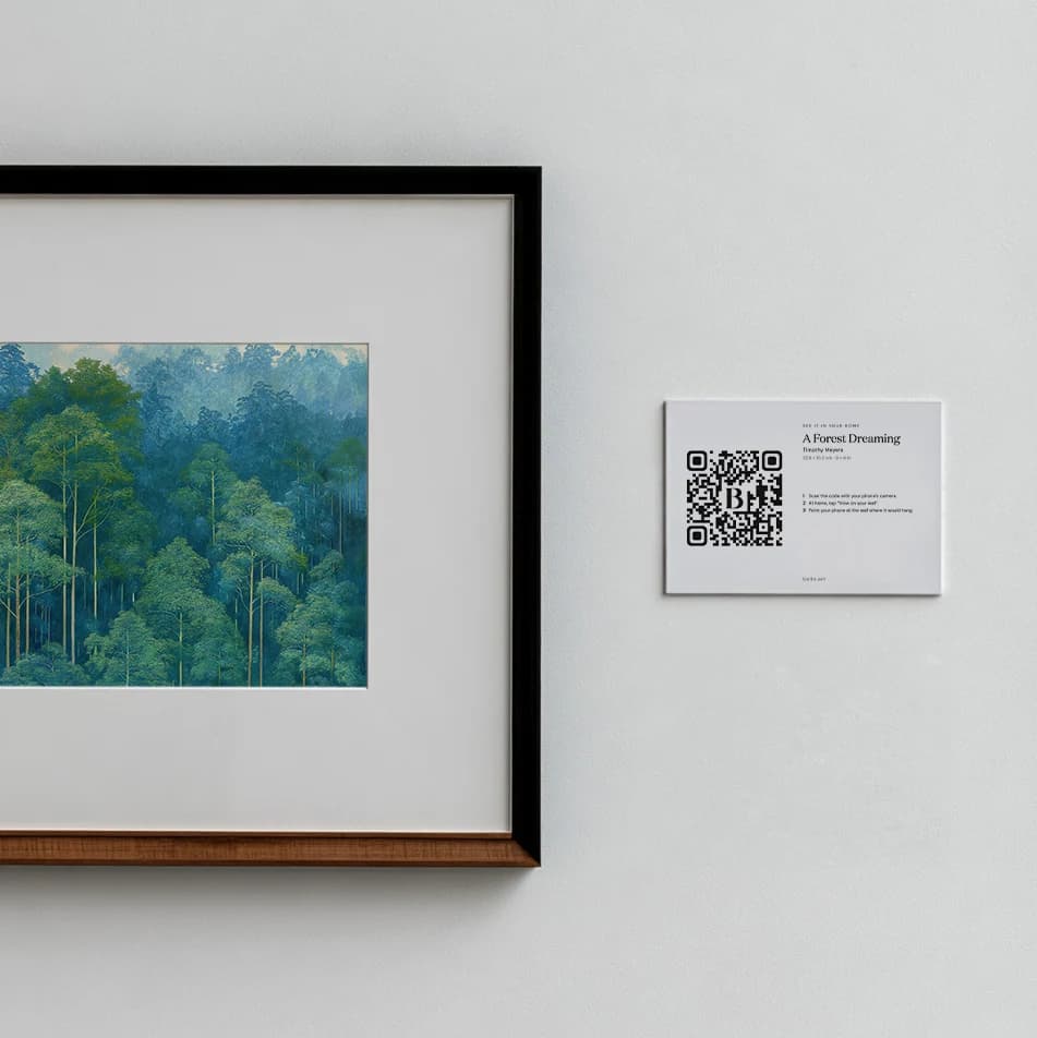 A framed print with a QR code wall label beside it