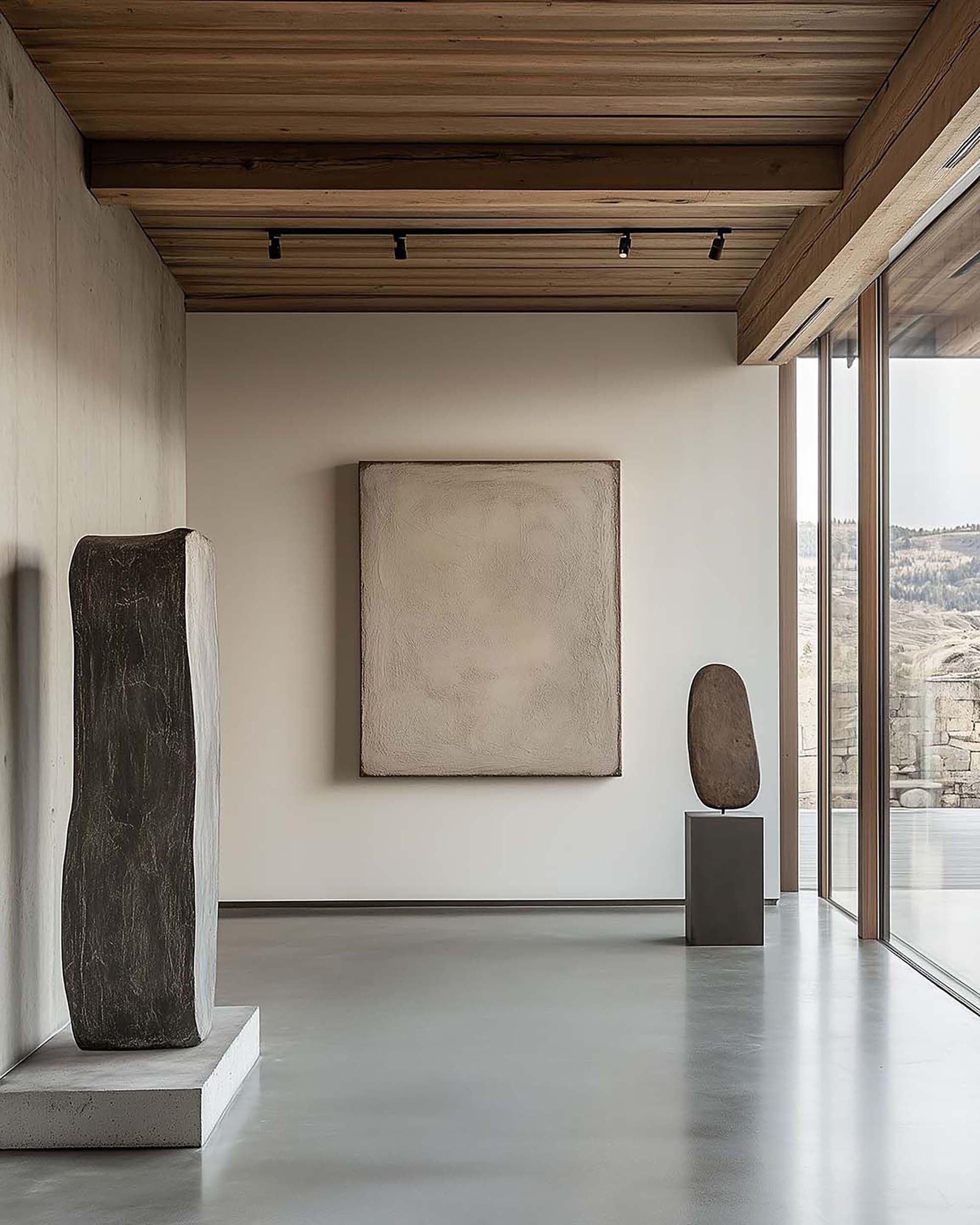 Minimal gallery-style hallway with a large wall-mounted frame, wood ceiling with track lights, and a sculptural pedestal near tall windows.