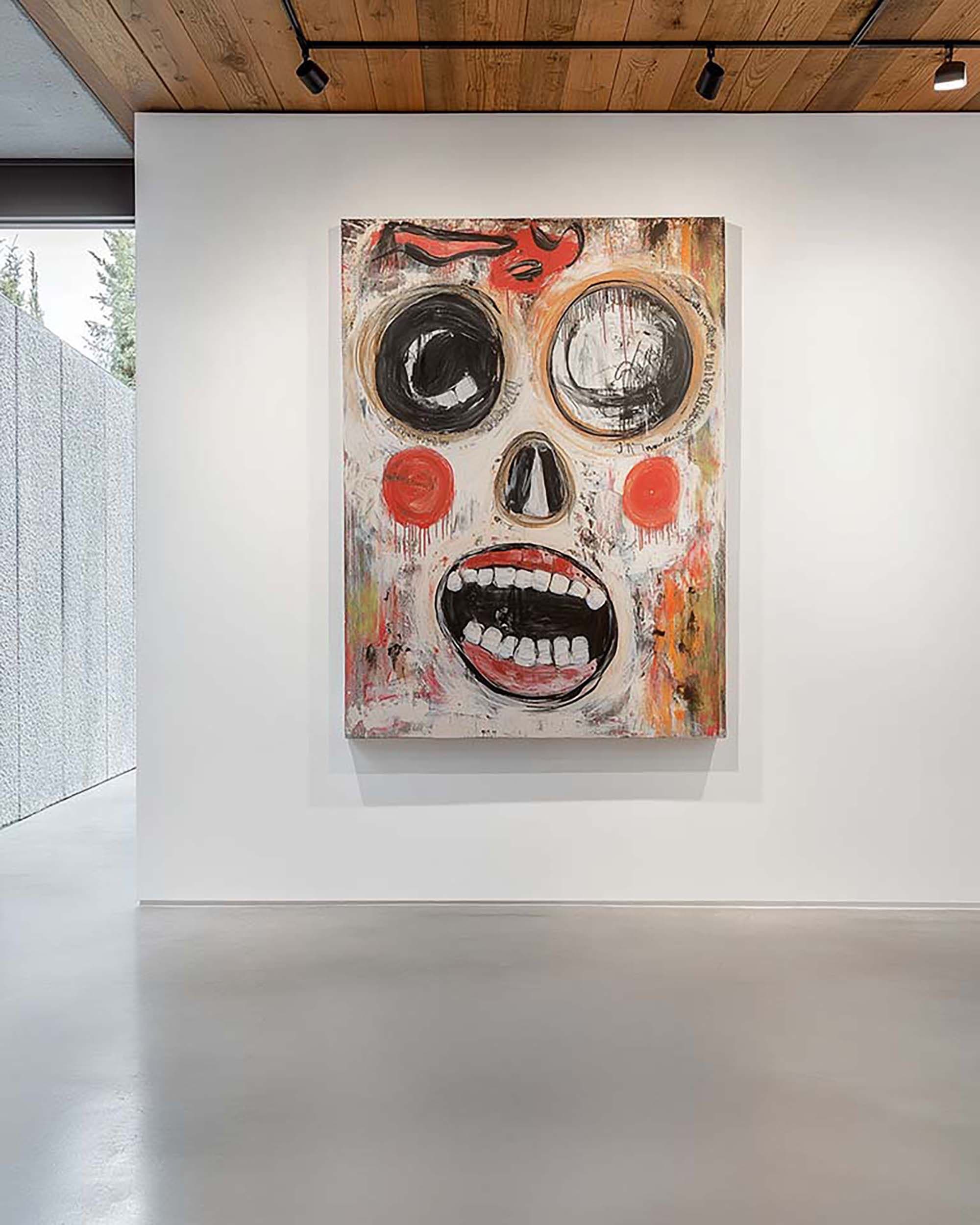 Modern gallery wall with a large framed artwork centered on a white wall beneath a wood ceiling with track lights.