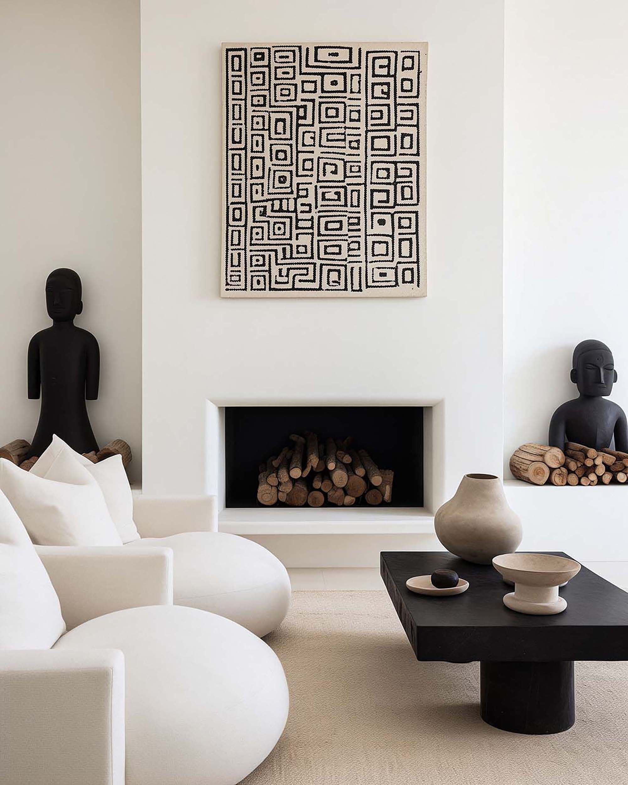 Minimal living room with a wall-hung frame above a recessed fireplace, plus a white sofa and black coffee table.