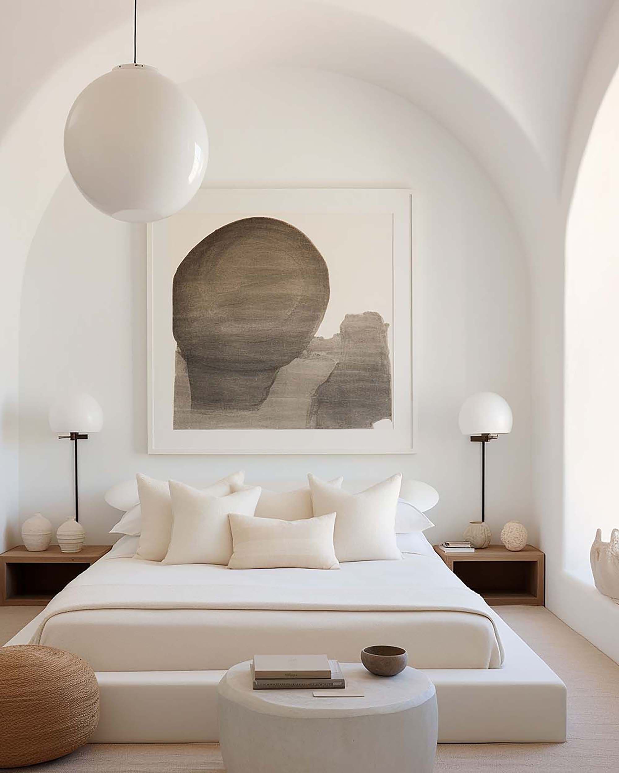 Minimalist bedroom with an arched ceiling and a large framed artwork above the bed, with globe lights on both sides.