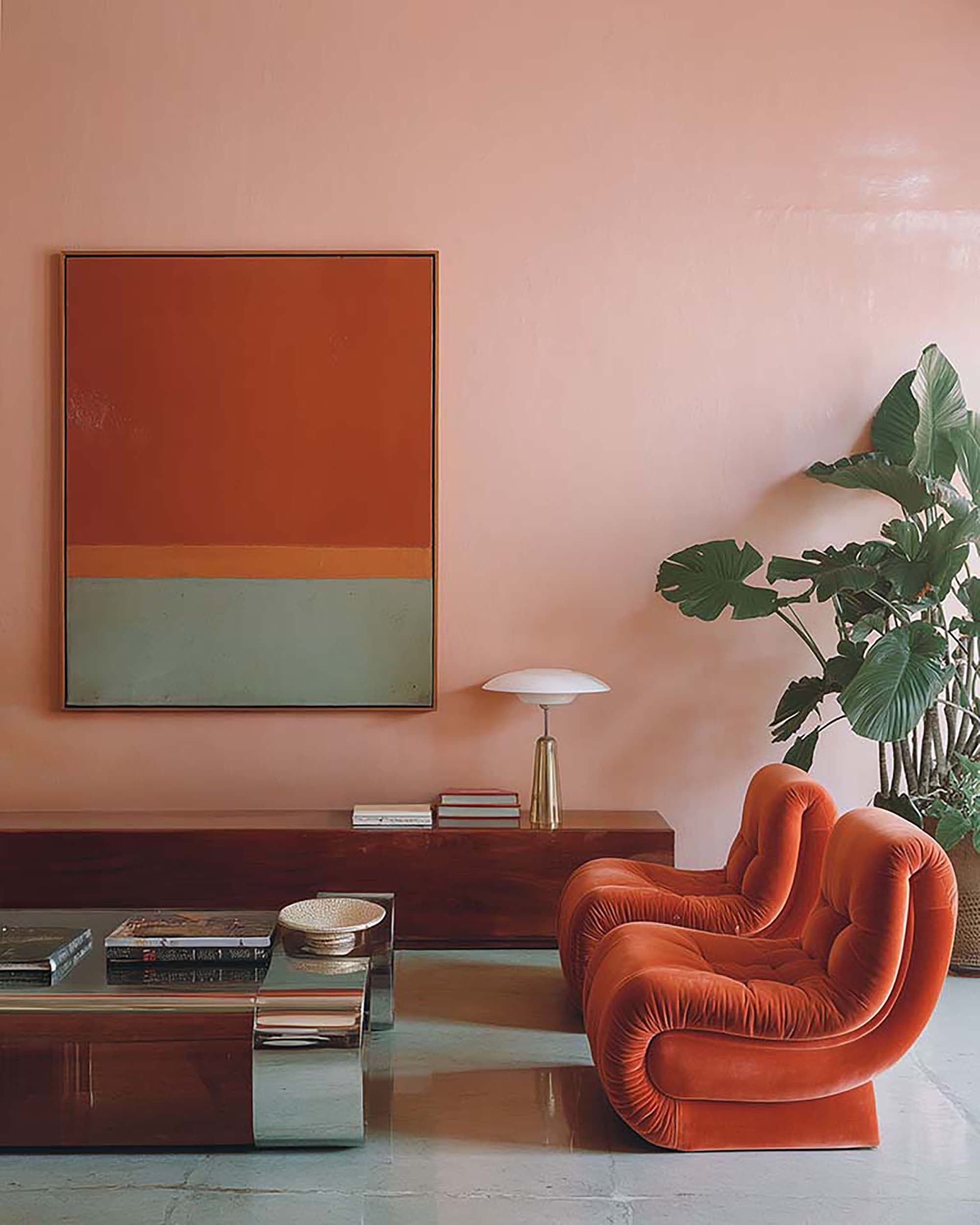 Living room wall with a large framed artwork above a low wood credenza, beside an orange lounge chair and a leafy indoor plant.