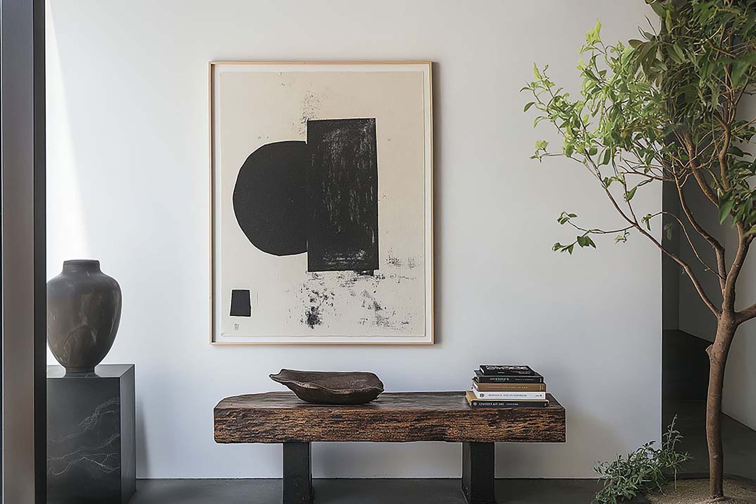 Minimal entryway wall with a light-wood framed print above a rustic wood bench, with a large floor plant to the right.