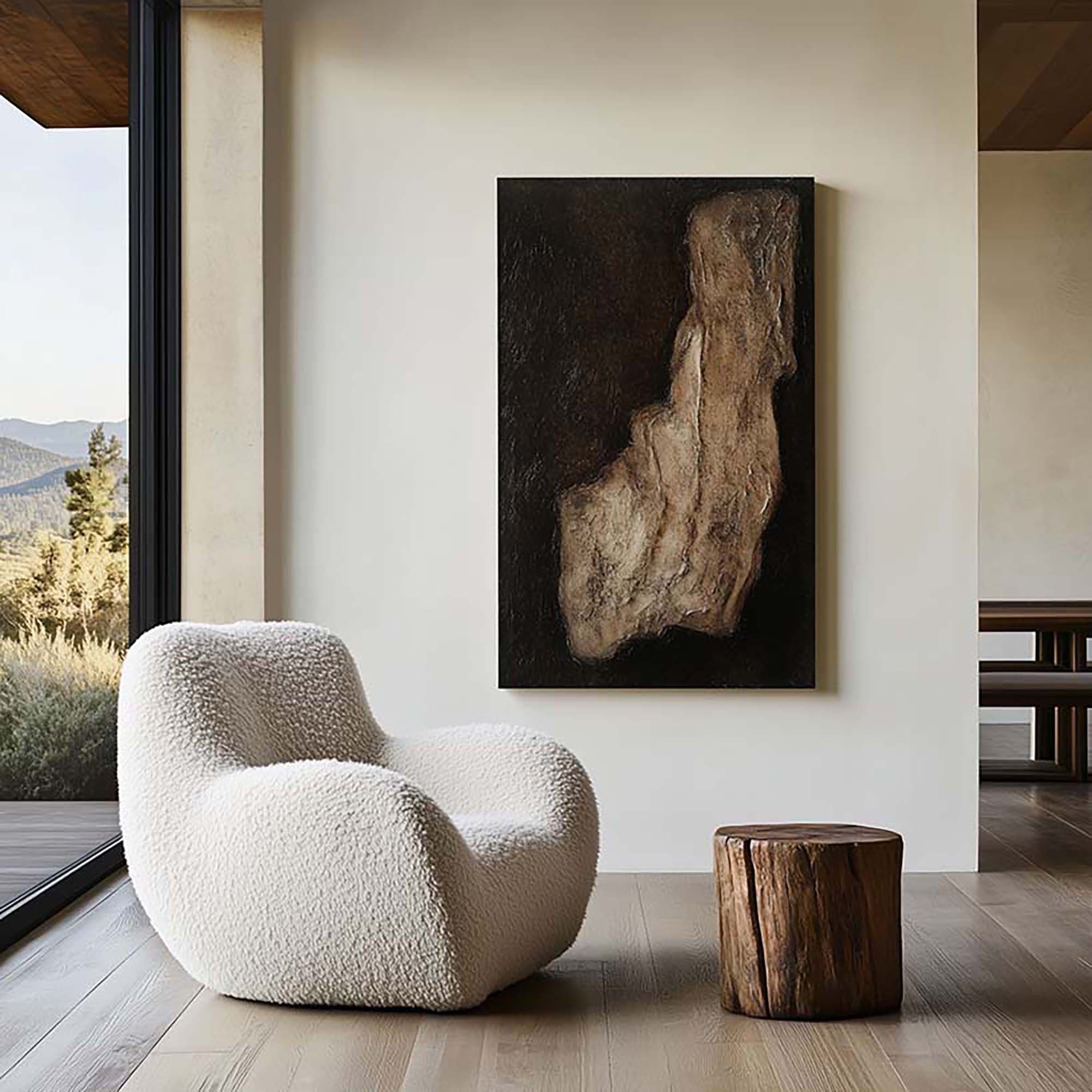 Minimal living room wall with a large framed artwork above a boucle lounge chair near a floor-to-ceiling window.